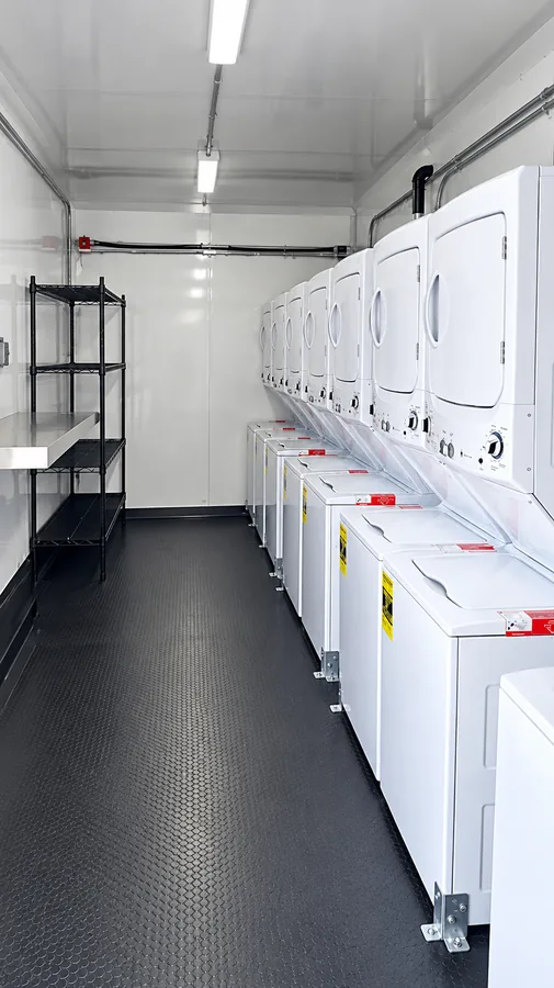 Commercial washers and dryers inside a mobile laundry trailer