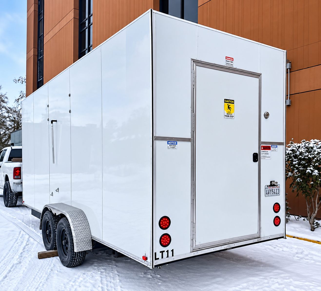 White enclosed trailer with rear access door in a snowy setting