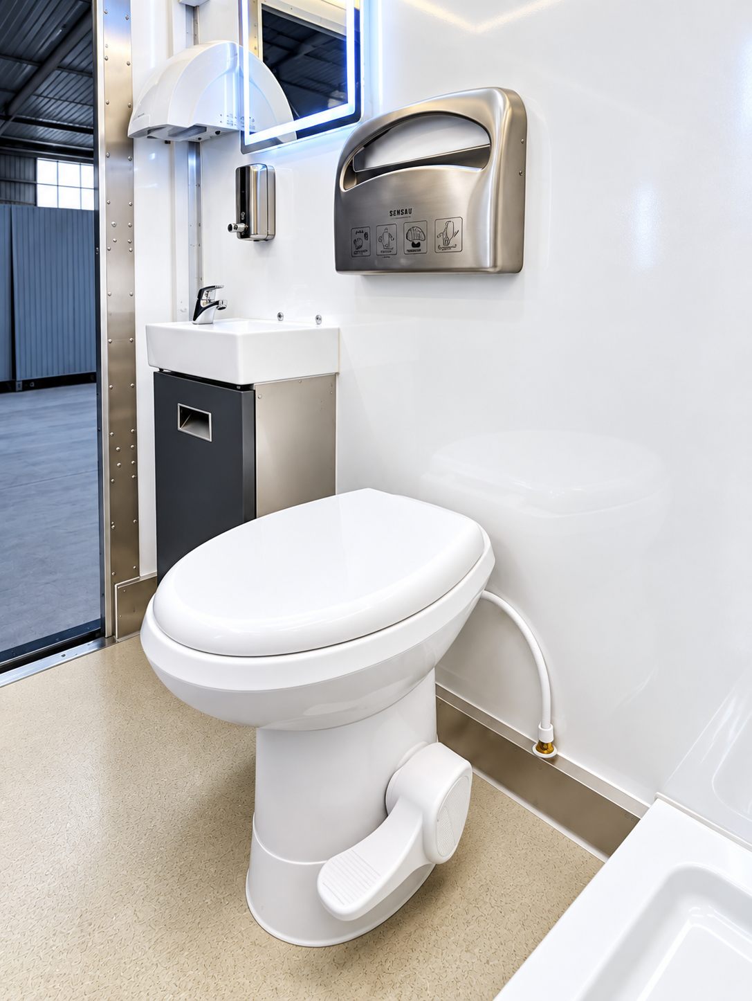 Compact restroom interior with toilet and handwashing sink
