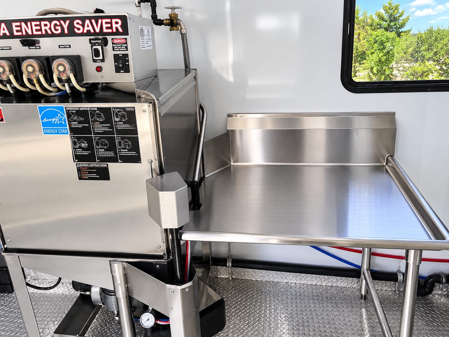 Stainless commercial dishwasher and work surfaces inside a trailer