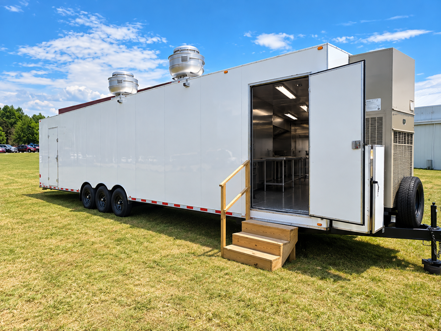 White mobile commercial kitchen trailer with entry steps and an open door